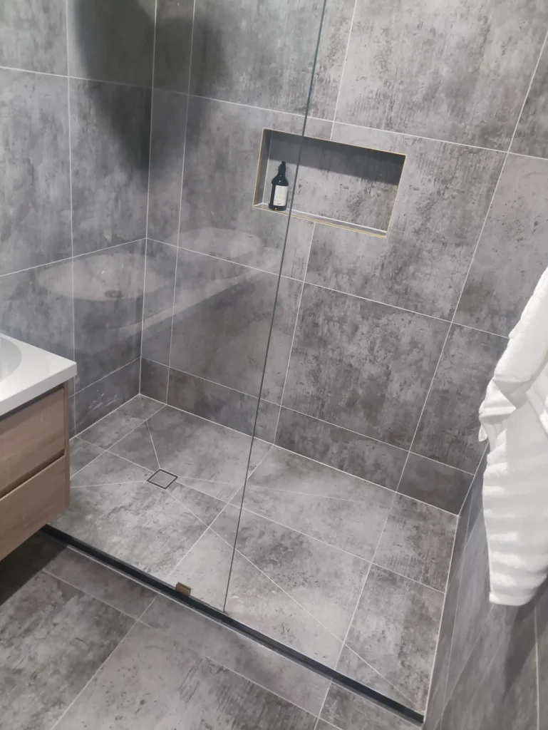 Grey concrete-look tiled shower with clean silicone seals, Melbourne bathroom